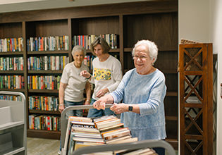three woman standing in the library